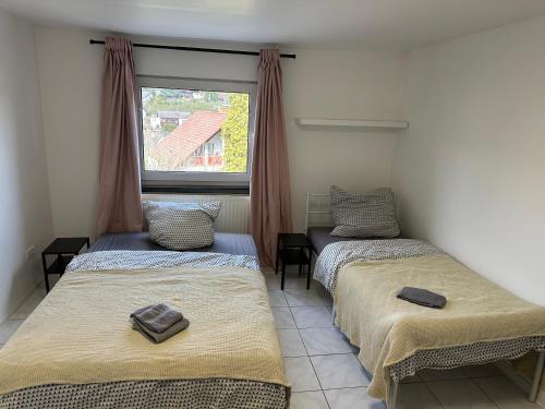 two beds in a room with a window at Zimmer für 2 Monteure in Heppenheim Kirschhausen in Kirschhausen