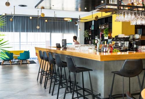 a bar with chairs and a person sitting at a counter at Prima City Hotel in Tel Aviv