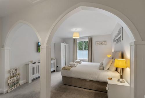 a white bedroom with a bed and an archway at Quayside Marina in Torquay