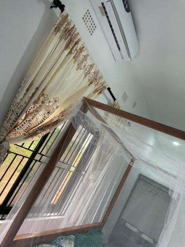a window in a room with curtains on it at Carinho da Paz in Inhambane