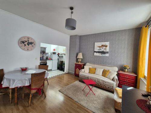a living room with a couch and a table at appartement meublé romain in Niederbronn-les-Bains