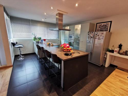 a kitchen with a large island with bar stools at Seraphina in Zaventem