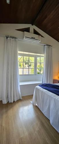 a bedroom with a bed and a window at Quarto Familiar Centro in Pomerode