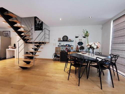 a dining room with a table and a spiral staircase at Seraphina in Zaventem