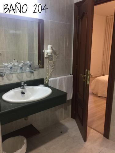 a bathroom with a sink and a phone on the wall at Hostal Vista Alegre in Castro-Urdiales