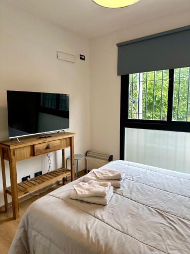a bedroom with a bed and a flat screen tv at Terrazas de Godoy in Godoy Cruz