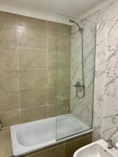 a bathroom with a shower and a tub and a sink at Terrazas de Godoy in Godoy Cruz