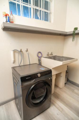 a washing machine in a kitchen next to a sink at Almond Tree Villa Beach Hideaway with Jacuzzi in Gros Islet
