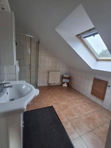 an attic bathroom with a sink and a window at Wandlitz-Pension Dampflok in Wandlitz
