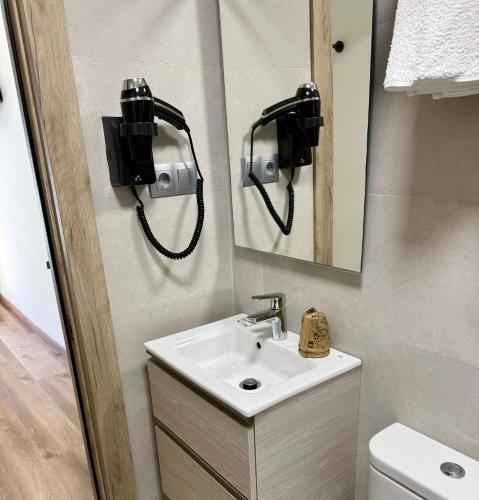 a bathroom with a sink and a phone on the wall at Hostal Fernández Atocha in Madrid