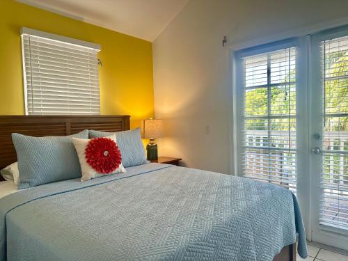 a bedroom with a bed with a red flower on it at Seas the Keys Getaway in Duck Key