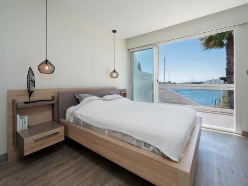 a bedroom with a bed and a large window at Villa Marina N173 - 5P6 in Le Grau-du-Roi