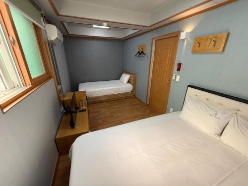a small room with two beds and a window at Gyeongju Bee House in Gyeongju