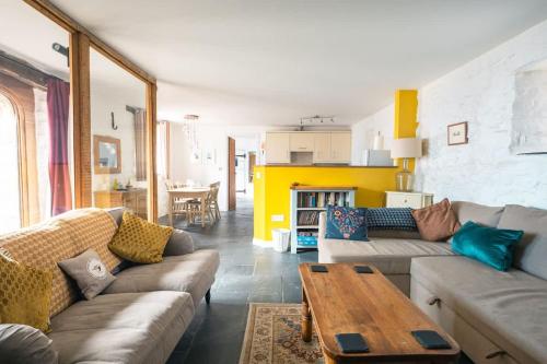 a living room with two couches and a table at St Davids Hideaway with Roll-top Bath & Log Burner in St. Davids