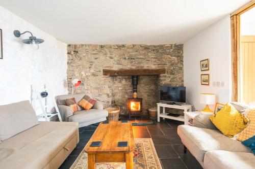 a living room with a couch and a table at St Davids Hideaway with Roll-top Bath & Log Burner in St. Davids