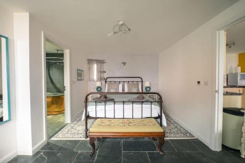 a bedroom with a metal bed in a room at St Davids Hideaway with Roll-top Bath & Log Burner in St. Davids
