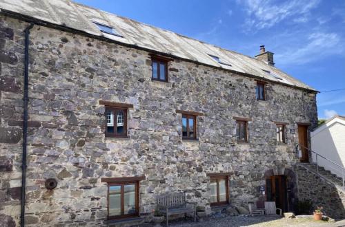 an old stone building with windows on the side of it at Stunning Converted Granary in Heart of St Davids in St. Davids