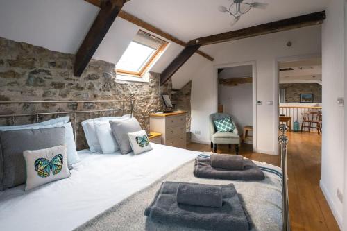 a bedroom with a large bed with two pillows on it at Stunning Converted Granary in Heart of St Davids in St. Davids