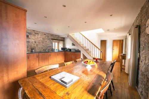a dining room with a wooden table with chairs at Stunning Converted Granary in Heart of St Davids in St. Davids