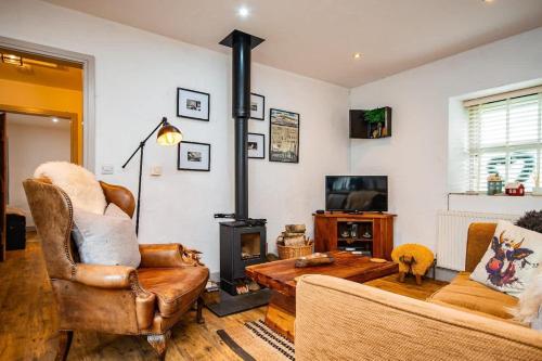 a living room with a wood stove and a couch at Cosy Farm Conversion In The Heart Of Pembrokeshire in Pembrokeshire