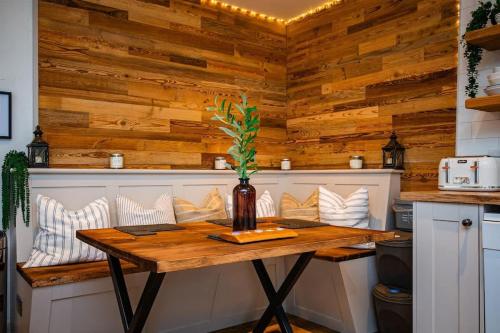 a table in a kitchen with wooden walls at Cosy Farm Conversion In The Heart Of Pembrokeshire in Pembrokeshire