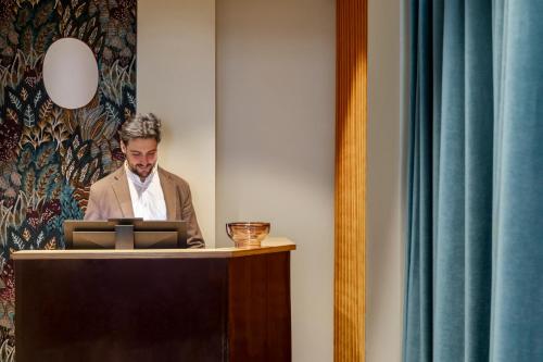 a man standing at a podium with a laptop at Barberini Retreat Boutique Hotel in Rome