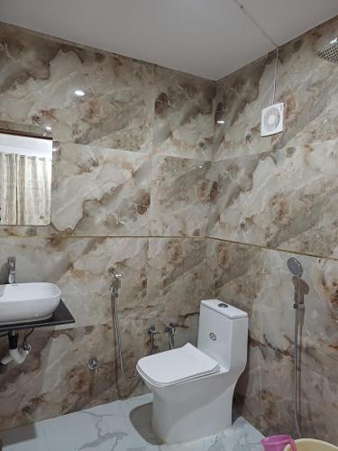 a bathroom with a white toilet and a sink at Orchha Best Homestay in Orchha
