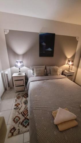a bedroom with a large bed and two night stands at Résidence Royal Plaza Menton in Menton