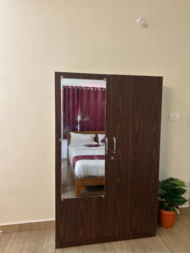 a bedroom with a bed and a door with a mirror at Villa The De Grise in Pondicherry