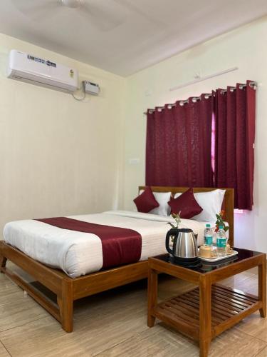 a bedroom with a large bed with red curtains at Villa The De Grise in Pondicherry