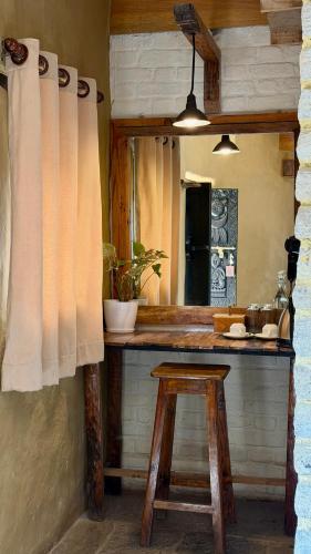 a kitchen with a counter with a stool and a mirror at Bhanjyang Village Lodge in Pokhara