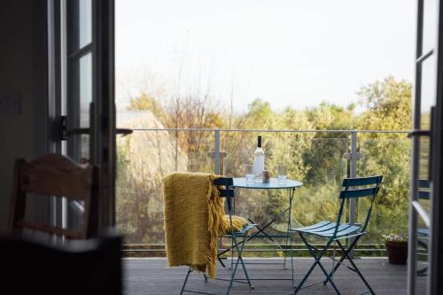 a table and two chairs on a balcony with a window at Converted Hay-loft with Stunning Countryside Views in Haverfordwest