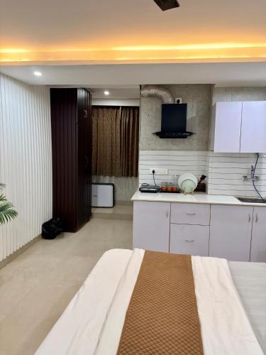 a kitchen with white cabinets and a tv in it at Halo Haven in Dehradun