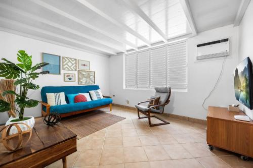 ein Wohnzimmer mit einem blauen Sofa und einem Sessel in der Unterkunft Casa Brisa in Aguada