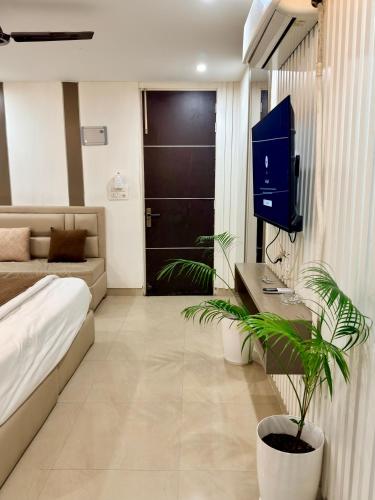 a living room with a bed and a tv in it at Halo Haven in Dehradun