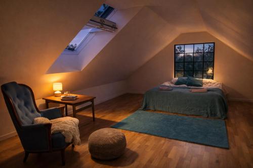 a bedroom with a bed and a chair and a window at The Studio in Skellefteå