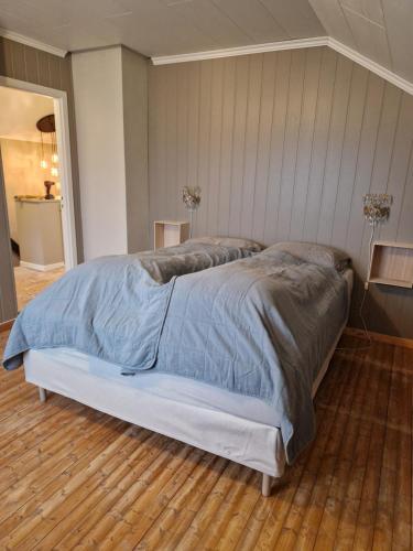 a large bed in a bedroom with a wooden floor at Vareid Panorama Lofoten Lysvollhuset in Vareid