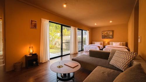 a living room with a couch and two beds at 陽月-Hizuki- in Nakijin