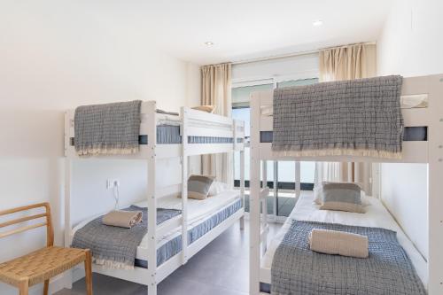 a bedroom with two bunk beds and a chair at Casa Cala Serena in Mijas