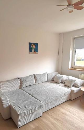 a white couch in a living room with a ceiling fan at DEBSI vacation rental in Bad Windsheim