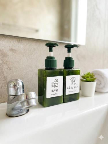 two bottles of soap sitting on a bathroom sink at Yankoi Mountains view in Chiang Dao