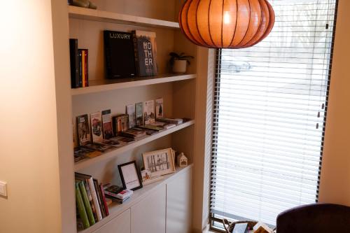 a room with a book shelf with books and a window at B&B Herinnering aan Brabant in Sint Michielsgestel