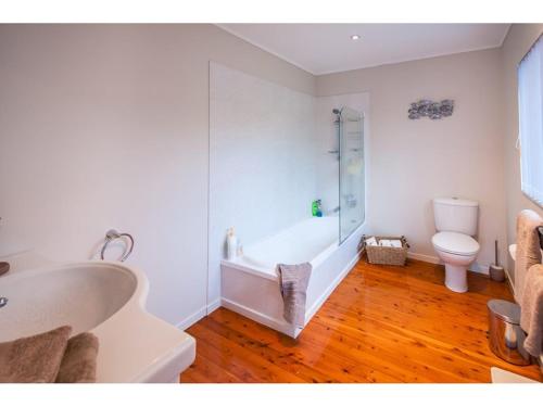 a bathroom with a tub and a sink and a toilet at Sea La Vie in the Bays in Auckland
