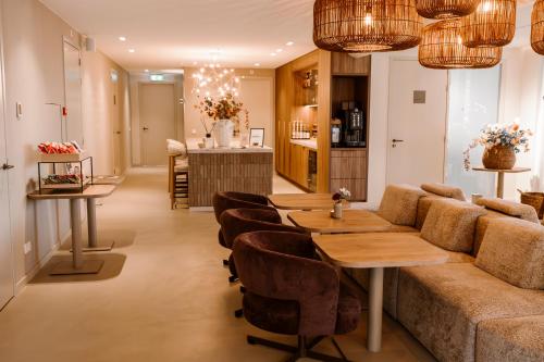 a living room with a couch and a table and chairs at B&B Herinnering aan Brabant in Sint Michielsgestel