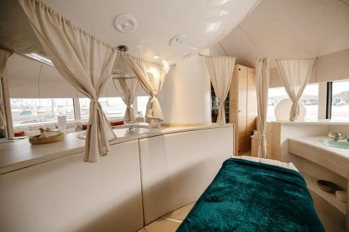 a room with a bed and a sink and windows at Le Nautica Hôtel in Perros-Guirec