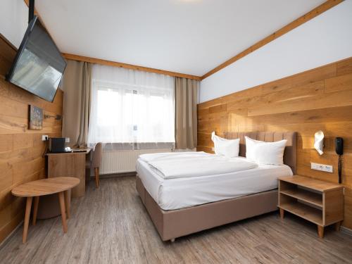 a hotel room with a bed and a television at DONAUHOTEL Ingolstadt in Ingolstadt