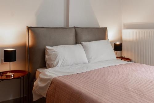 a bedroom with a bed with two lamps on tables at Pineios View New Apartment in Larisa