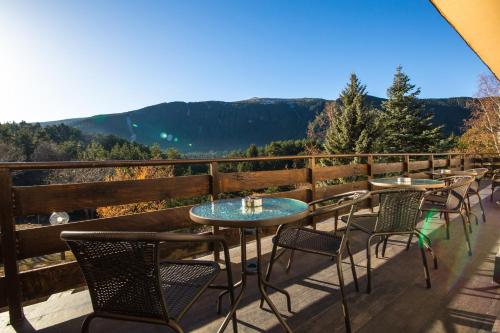 a row of tables and chairs on a balcony with mountains at Hotel Panorama in Panichishte