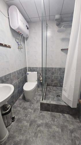 a bathroom with a shower and a toilet and a sink at Очир зочид буудал in Dalandzadgad