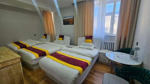 a hotel room with two beds and a table at Очир зочид буудал in Dalandzadgad